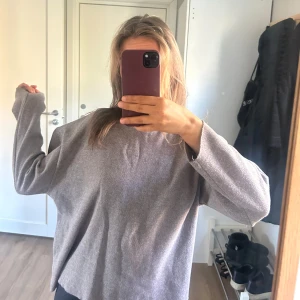 Grå oversized stickad tröja - Mysig grå ish beige, svårt att beskriva färgen. Stickad tröja med rund halsringning och långa ärmar. Tröjan har en oversized passform.
