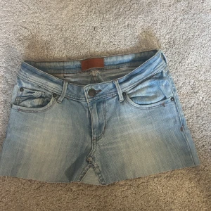 Ljusblå lågmidjad jeanskjol - As snygg lågmidjad jeans kjol. Är något ojäm längst ner då jag klippt av den så den skulle vara något kortare men rättas lätt till och är inget som märks eller syns när den sitter på.passar xs-m då den är stretchig