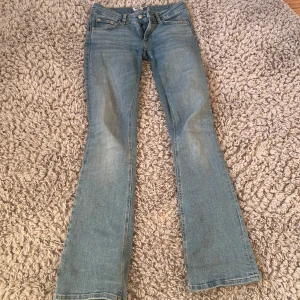 Ljusblå bootcut jeans i full längd - Snygga ljusblå jeans med bootcut-modell och klassisk femficksdesign. Jeansen har låg midja och är i full längd, som dessutom är nersydd till ännu lägre midja och i väldigt bra skick 
