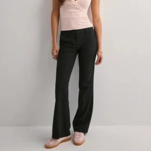 Svarta kostymbyxor  - Snygga svarta kostymbyxor från Nelly i modellen ”low waist flare suit pant”. Byxorna är i nyskick och säljs endast för att jag inte använder dem.