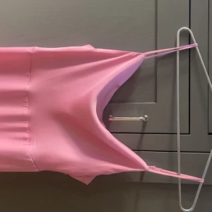 Rosa balklänning - Säljer denna superfina balklänningen som endast används en gång! Den är i satinmaterial med en djup rygg och justerbara axelband. Perfekt i längden för mig som är runt 160! Köpte för 800 men säljer för 400 då den är i helt nytt skick, men priset går att argumentera!🩷