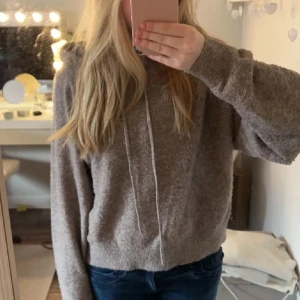 Beige stickad hoodie - Mysig beige stickad hoodie med luva och dragsko. Hoodien är använd 2-3 gånger men köptes begagnad och är lite nopprig, men är i ett bra skick. 
