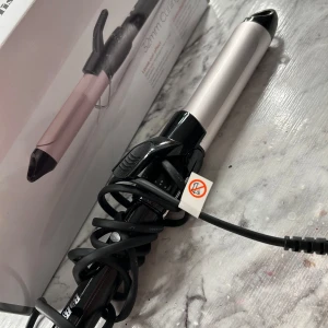 Locktång från Babyliss - Säljer en 32mm locktång från Babyliss i silver och rosa. Perfekt för att skapa lösa lockar. Den har en sladd med roterande fäste för enkel användning. Köp inte  utan att ha frågat, ge prisförslag! ALDRIG ANVÄND. köpt för 799kr