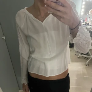 Fin blus med detaljer - Säljer denna fina blus med blommor på ärmarna som är som hål, har en tröja under på bilden så lite genomskinlig är tröjan, men annars jätte fin💕💕