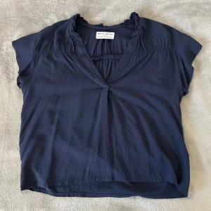 Mörkblå blus från Holly & Whyte - Snygg mörkblå blus från Holly & Whyte med v-ringning och korta ärmar. Säljer då den blivit för liten för mig💕