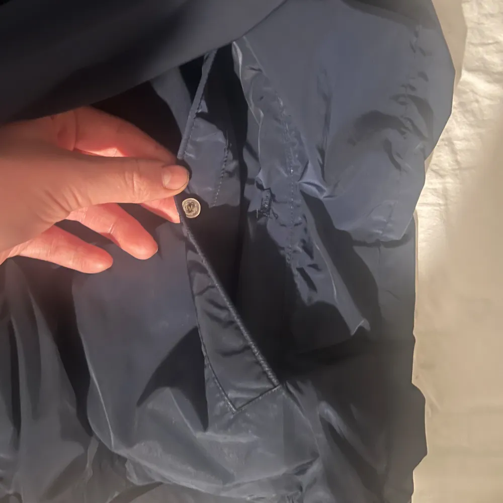 Säljer nu min mörkblåa vindjacka från Moncler storlek 2 M/L. Tags finns kvar Scan på loggan finns även qr kod inuti. Säljes då den inte används fint skick små defekter allt visas på bilderna. Hör av er om ni är intresserade eller vid frågor! Mvh Jakob!.  . Takit.