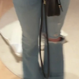 Blå slitna jeans - Snygga blå jeans med slitningar och bootcut-stil. Perfekta för en avslappnad look med en touch av edge. De har en klassisk jeansfärg och är designade för att sitta bekvämt. Skit snygga men kommer tyvärr inte till användning längre! Säljer på grund av för att de är för små🥰💖