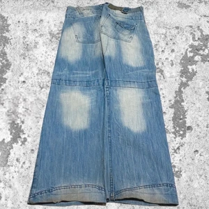 Vintage blå jeans med breda ben - Säljer ett par riktigt coola vintage jeans med breda ben. De är ljusblå med en sliten look och har flera fickor fram och bak. Perfekta för en avslappnad och retro stil! Säljer vidare då de inte passade mig🫶🏼