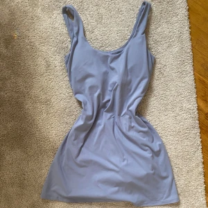 Oysho träningsklänning - Fin träningsklänning från Oysho i strl M med inbyggda shorts och telefon ficka, knappt använda