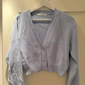 Stickad kofta - Använd men bra skick. Ljusblå kofta med knappar. Kort passform. 