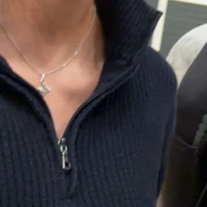 Svart stickad tröja med dragkedja - Säljer en snygg och stilren svart stickad tröja med dragkedja (3/4 zip). Perfekt för kyliga dagar och passar både till vardags och lite finare tillfällen. Tröjan har en hög krage och långa ärmar, vilket gör den extra mysig.