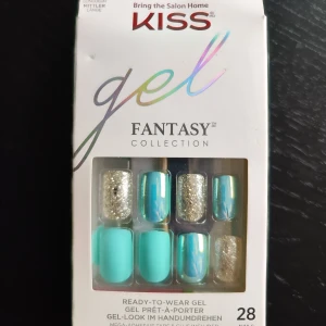 KISS Gel Fantasy Collection - KISS Gel Fantasy Collection är en färgglad och glittrig uppsättning av färdiga gelnaglar. Setet innehåller 28 naglar i olika stilar, inklusive turkosa och glittriga varianter. Perfekt för en snabb och enkel manikyr hemma som håller upp till 7 dagar. Inkluderar både enfärgade och mönstrade naglar för en unik look.