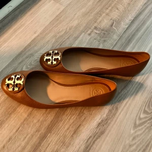 Tory burch ballerinaskor  - I nyskick då det är använd endast få gånger. Skorna är i konjaks brun med guld logga.