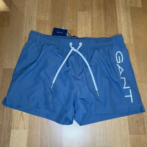 Gant badbyxor i storlek L - Gant Badbyxor oanvänd hett ny  Storlek L Färg ljus blå Korta i modellen 