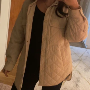 Quilted Jacket  - Säljer min quilted jacka i beige. Den är lång, lightweight och väldigt bekväm, nästan oanvänd och i toppskick. Perfekt för lager på lager och passar till många olika stilar! Den säljs inte längre, så passa på att få tag på den här!