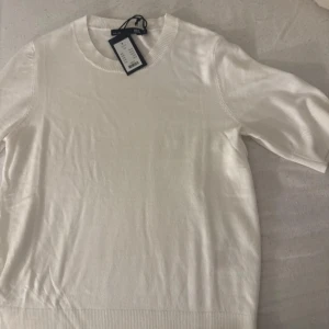 Vit tröja från lager 157 - Säljer en stilren vit tröja från Lager 157. Tröjan har en rund halsringning och korta ärmar. Perfekt för en klassisk och avslappnad look. Passar till många olika tillfällen.