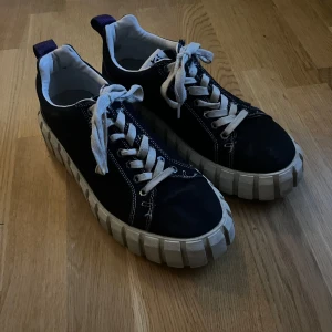 Svarta sneakers från Eytys - Snygga svarta sneakers från Eytys med vit sula och snörning. Skorna har en unik design med grov sula och vita detaljer. Enda defekt är på snörena är lite slitna!🥰