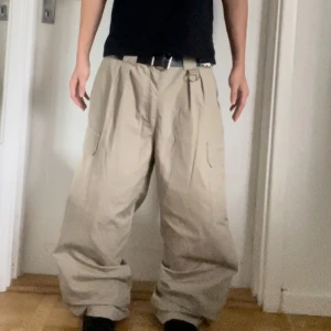 Beige cargopants - Säljer ett par beige cargopants med loose fit och flera praktiska fickor. Byxorna har en avslappnad stil och är perfekta för en casual look. De är designade med låg midja och breda ben.
