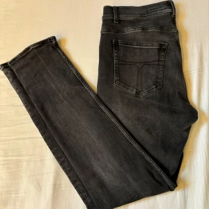 Tiger of Sweden jeans - Skitfeta svarta jeans från Tiger of Sweden, de är W33 L32. De är lagade på ett ställe(se sista bilden) men inget man tänker på när man använder dom direkt. Hör av er vid eventuella frågor!!