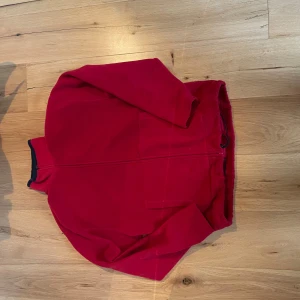 Röd fleece jacka från roundtree and yorke - Säljer denna gosiga och mysiga fleecen köpt på second hand. Tröjan är ganska oversized och sitter väldigt pösigt, men kan hålla dig varm genom alla väder.