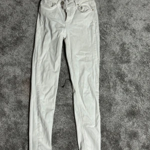 Vita jeansbyxor - Snygga vita jeansbyxor med en klassisk design. De har en smal passform och är perfekta för en stilren look. Byxorna har fickor fram och bak samt en knapp- och dragkedjestängning.