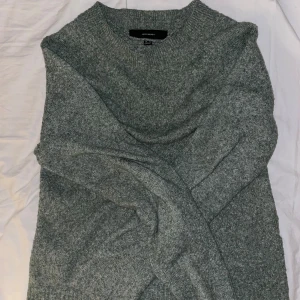 Grön stickad tröja från Vero Moda - Mysig grå stickad tröja från Vero Moda. Perfekt för kyliga dagar med sin bekväma passform och långa ärmar. Enkelt och stilrent plagg som passar till det mesta.