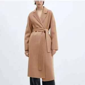 Brun kappa från mango - Mango kappa i medium Brown. Nypris 1799kr. Mitt pris 650kr. Storlek XS men passar även S. Använd ca 3 gånger totalt och som ni ser på sista bilden så sitter fortfarande bandet fast i kappan, vilket du som köper den kan klippa av sedan. Den säljs eftersom den inte kommer till användning. Hör av dig för frågor eller fler bilder🥰 Skulle säga att den är lite ”kamel” färgad”