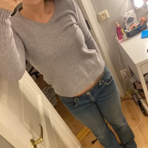 Grå tröja från VILA - Säljer en grå tröja från VILA med v-ringning. Tröjan har blivit noprig längst ner på ärmarna på baksidan. Skriv för mer bilder. 