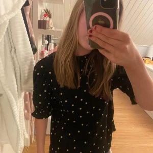 Svart prickig blus från Holly & White - Säljer en svart blus med vita prickar från Holly & White. Blusen har trekvartsärmar och en bekväm passform. Perfekt för en stilren look! Annvänd 1 gång                                                            Orginalpris: 299kr