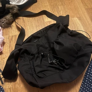 Svart ryggsäck med dragkedja - Säljer en praktisk svart ryggsäck med justerbara axelremmar och flera fack. Väskan har en dragkedja och en stilren design, perfekt för vardagsbruk eller utflykter.