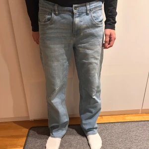 Levi's Loose Taper Jeans - Säljer ett par ljusblå Levi's Loose Taper jeans. De har en avslappnad passform med avsmalnande ben och klassisk femficksdesign. Perfekta för en casual look.