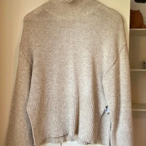 Stickad Beige Tröja - Superfin stickad tröja från ginatricot. Slits i sidorna. Långa ärmar & lagom hög i kragen. Perfekta tröjan till hösten. Stl S men passar även XS. Nyskick! 