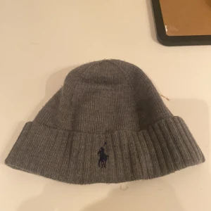 Ralph lauren mössa - Köpt på Nelly man  Knappt använd kanske 7 tillfällen i vintras och nu säljer jag den då jag inte tyckte den passade så bra på mig