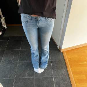 Säljer ett par snygga ljusblå bootcut jeans. De är lågmidjade och har en klassisk femficksdesign med snygga detaljer vid fickorna. Perfekta för en avslappnad vardagslook! Utsvängda. Innerbenslängden är 82 och midjemått 37,5 