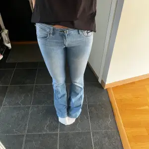 Säljer ett par snygga ljusblå bootcut jeans. De är lågmidjade och har en klassisk femficksdesign med snygga detaljer vid fickorna. Perfekta för en avslappnad vardagslook! Utsvängda och passar de som är lite längre 