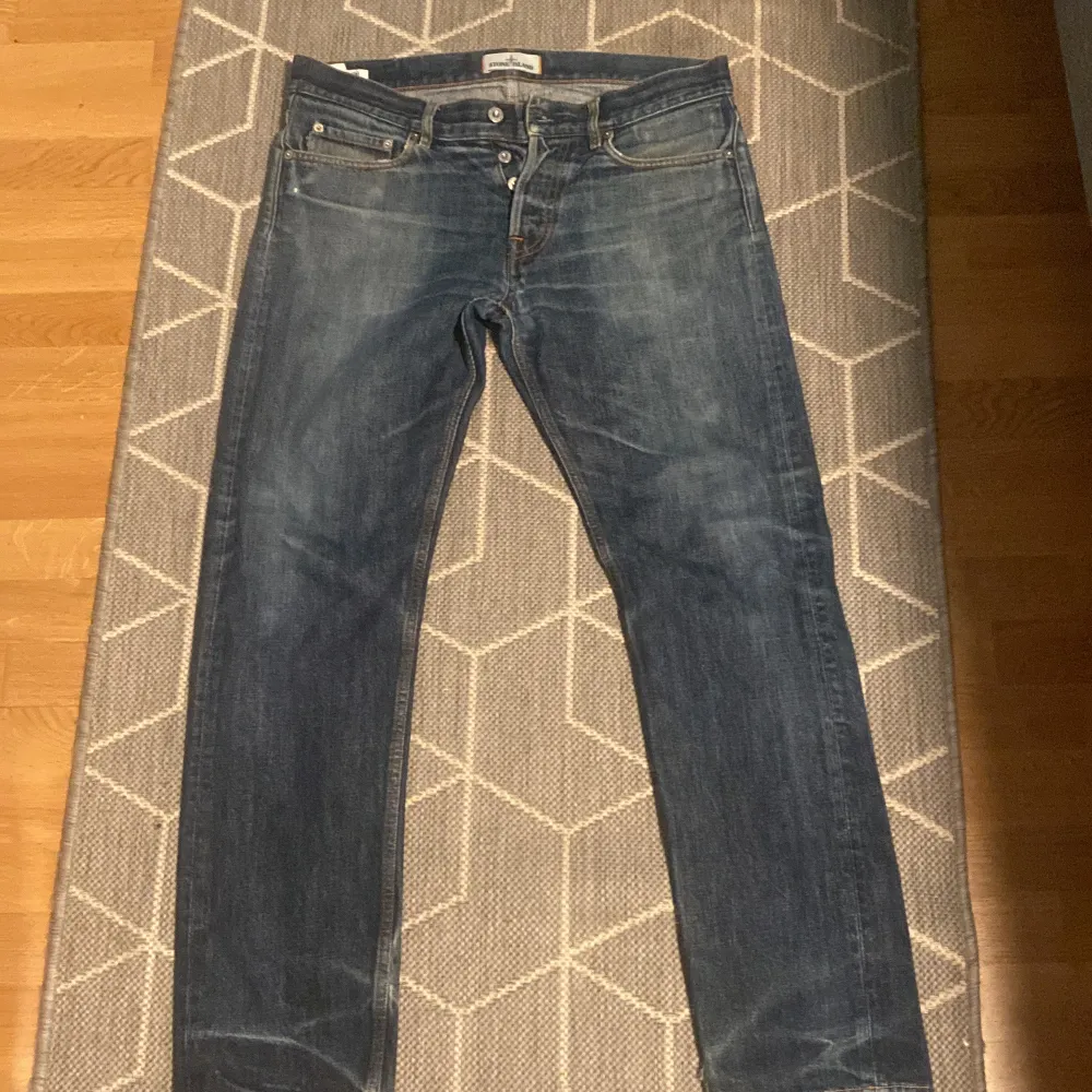 Säljer ett par snygga blå jeans från Stone Island. De har en klassisk femficksdesign och en cool tvättad look. Jeansen är i storlek W31 L34 och har en normal passform. Perfekta för både vardag och fest!. Jeans & Byxor.