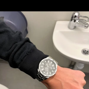 Silverfärgad klocka från Regal - Säljer en snygg och stilren silverfärgad klocka från Regal. Den har en robust metallarmband och en detaljerad urtavla med flera små urtavlor för extra funktioner. Perfekt för både vardag och fest!