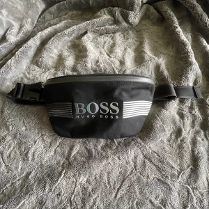 Hugo Boss Midjeväska - Säljer min Boss midjeväska då den aldrig används och aldrig har använts!  Storlek: ONESIZE Skick: ALDRIG ANVÄND Pris: -:599 Nypris var ca 1000-1500, men de säljs ej längre.  Fler bilder eller om du har frågor kontakta mig i DM🤝