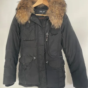 Hollies Jacka - Jacka från Hollies, sparsamt använd. Storlek 34.  Finns inbyggd luva. Inga fläckar eller skador. Äkta päls som går att ta av. Inköpt för 4500kr