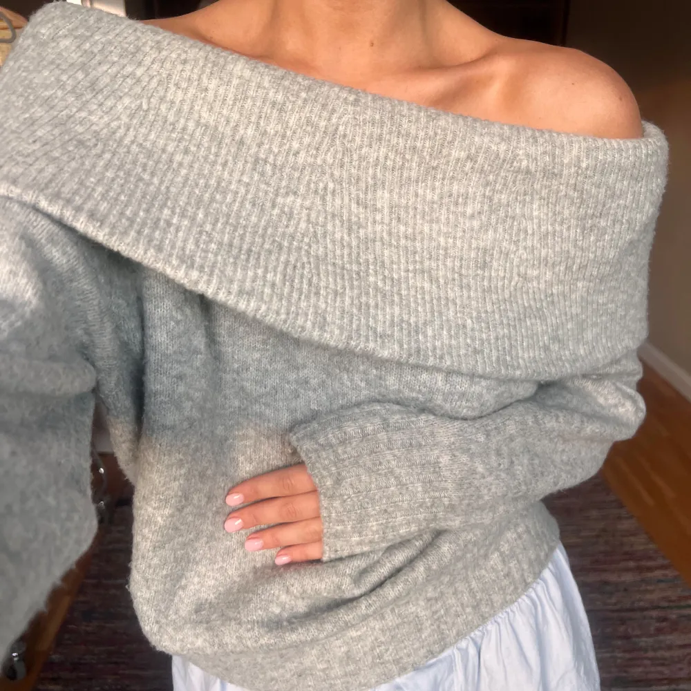 Säljer en supermysig grå offshoulder tröja som är perfekt för kyliga dagar. Den är stickad och har långa ärmar, vilket gör den både stilren och bekväm. Passar perfekt till både vardag och fest!. Tröjor & Koftor.