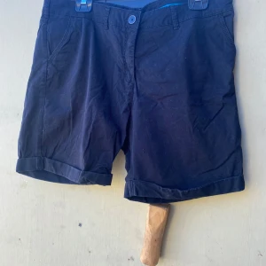 Svarta shorts från H&M - Säljer ett par svarta shorts från H&M. De är i storlek 46 och har en klassisk design med uppvikta benslut och fickor både fram och bak. Perfekta för en avslappnad sommarstil!