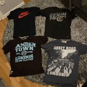 Fyra t-shirts - Säljer fyra t-shirts med olika tryck. En svart Nike t-shirt med röd logga, en svart t-shirt med denim-tryck, en svart t-shirt med Camden Town och London text i blått, och en grå t-shirt med Abbey Road motiv och London text i vitt. Alla tröjor 500. Enskilt 150 kr styck. Storlekar XS/S