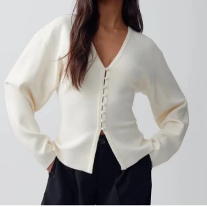 Vit kofta med knappar - Säljer en stilren vit kofta med v-ringning och knappar framtill. Koftan har långa ärmar. Knappt använd