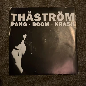 Thåström - Pang Boom Krash / Monolog 7” vinylsingel  - Vinylskiva med Thåström, innehållande låtarna 'Pang Boom Krash' och 'Monolog'. Utgiven av Mistlur Records 1989. Skivan spelas på 45 rpm och har katalognummer MLRS 73.