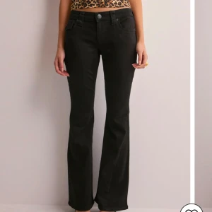 Svarta flare jeans från True Religion - Snygga svarta flare jeans från True Religion med låg midja. Byxorna har en klassisk femficksdesign och en knappdetalj på baksidan, Köpta i oktober  förra året för 1500 på therlunds och säljer för att dem inte passar, storlek 28/29, priset kan diskuteras!!