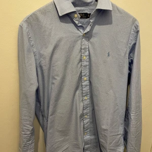Blå rutig skjorta från Ralph Lauren M - Snygg blå rutig skjorta från Ralph Lauren i 100% bomull. Perfekt för en stilren look. Mycket bra skick. Hör av er vid frågor. 