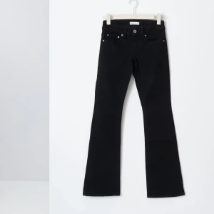 Svarta low waist bootcut jeans - Snygga svarta bootcut jeans med låg midja och med en numera klassisk ficksdesign. Perfekta för en retro Y2K-look. Jeansen har dekorativa knappar på bakfickorna och en stilren passform. säljer dessa svarta low waist bootcut jeans från gina, köpta för 1 månad sen, aldrig använda men tog av prislappen direkt efter köpet och kan därför inte lämna tillbaka. Jätte stretchigt material och därför även jättesköna. Storlek 40 men passar som 38 men lite för stora för mig.