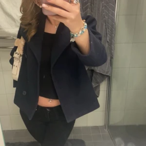 Mörkblå kavaj - Snygg mörkblå kavaj med dubbelknäppning och klassisk krage. Perfekt för en stilren look. Passar bra till både jeans och mer uppklädda outfits. Använt den mycket, men ingen skada på den!