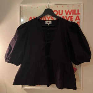 Ganni svart topp - En superfin svart topp från Ganni. Inga defekter och tvättad endast två gånger. Använd ett fåtal gånger. Finns i butik för 1895kr. Storlek 34/XS. 
