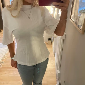 Vit kortärmad topp med dragkedja - Snygg vit topp med en dragkedja i ryggen. Endast använd 1 gång!❤️